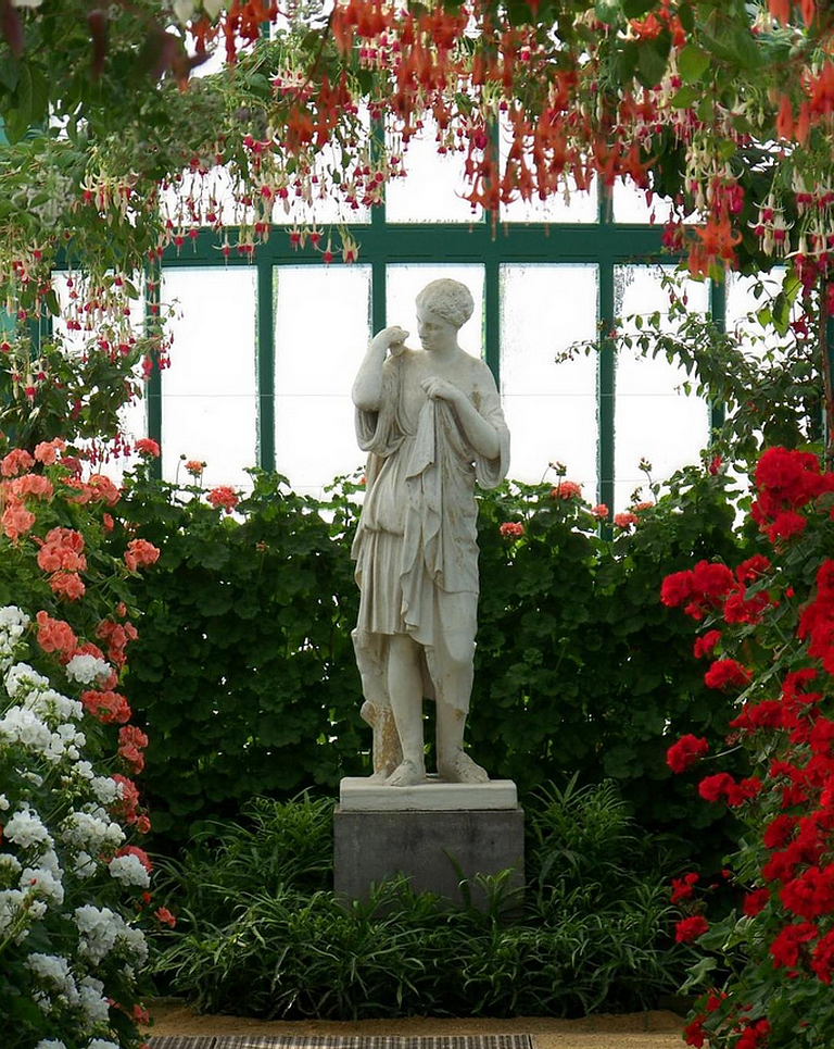 Хорошая композиция из цветов и декоративных элементов значительно украсит сад-оранжерею