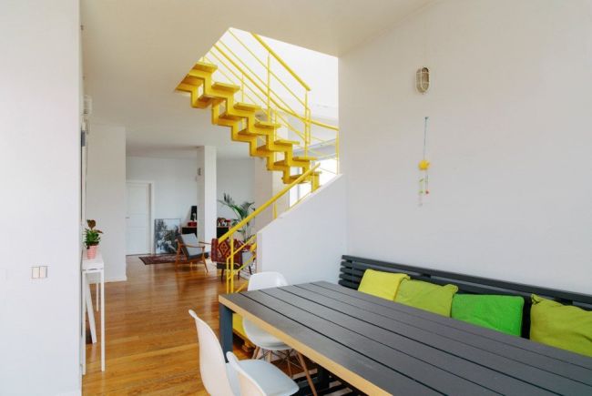Лестница на второй этаж выкрашена в яркий желтый цвет