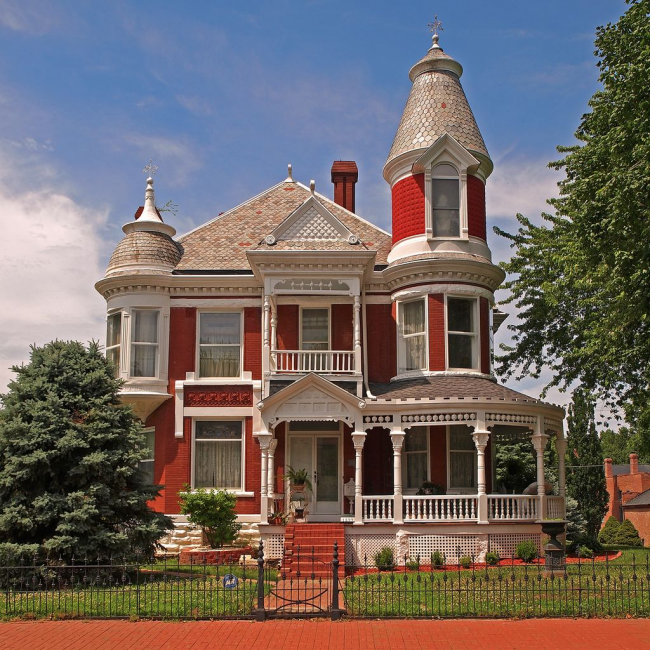 Яркий красно-белый дом с маленькой круглой жилой башенкой