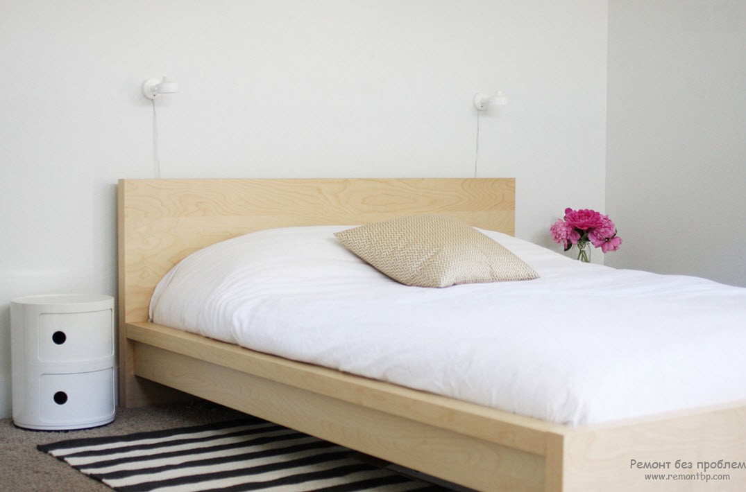 Спальня в стиле минимализм. Кровать простой формы из светлого дерева