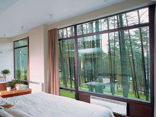 Спальня с большими окнами внутри частного дома