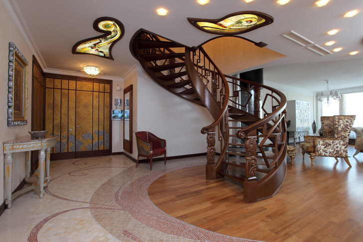 Холл в модерн стиле с винтовой лестницей на второй этаж оборудован "правильной", функциональной мебелью. Встроенные гардеробные позволяют экономить пространство и не делают его захламленным. 