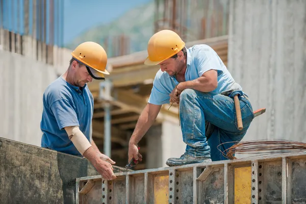 Два строительных рабочих, установка рамы бетона опалубка — стоковое фото
