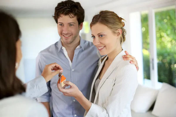 Счастливая молодая пара, получающая ключи их нового дома — стоковое фото