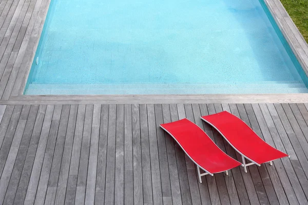 Вид красного шезлонгах, установленных плавательный бассейн — стоковое фото
