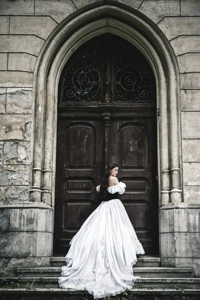 Загадочная женщина в викторианской одежде с старой двери — стоковое фото