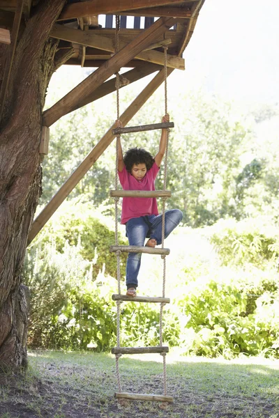 Мальчик, восхождение веревочная лестница в домике на дереве — стоковое фото