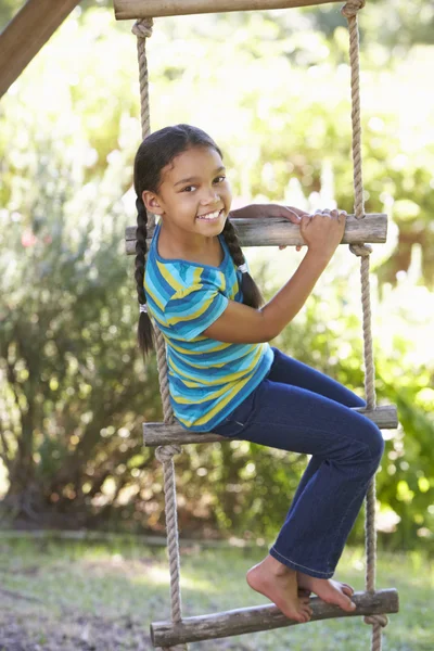 Девушка, восхождение веревочная лестница в домике на дереве — стоковое фото
