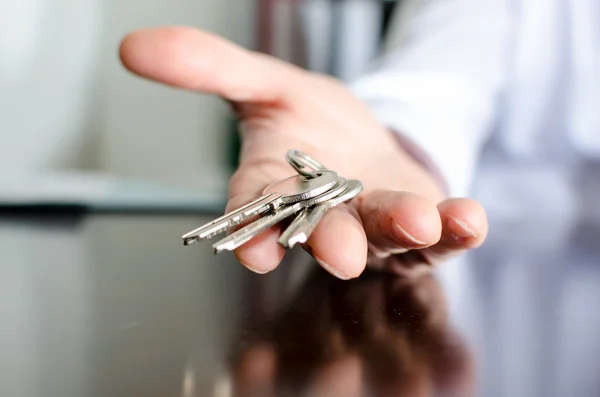 Ключи от дома показаны агент по недвижимости — стоковое фото