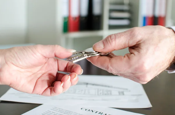 Агент по недвижимости, дающий ключи от дома клиенту — стоковое фото