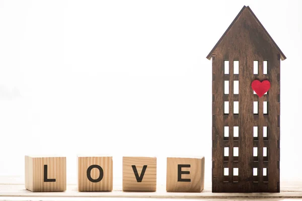 Любовный знак и модель деревянного дома — стоковое фото