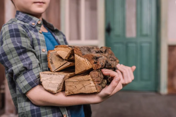 Мальчик, собирающий деревянные бревна — стоковое фото