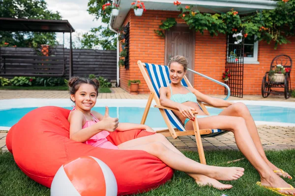Mother Smiling Daughter Resting Swimming Pool Backyard Summer Day — стоковое фото