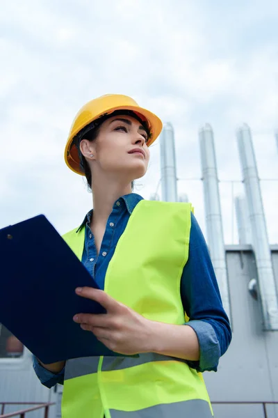 Bottom View Beautiful Female Architect Safety Vest Hardhat Writing Clipboard — стоковое фото