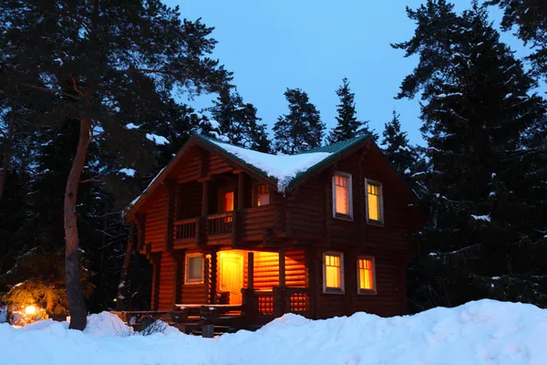 Деревянный дом в зимний лес в Сумерки — стоковое фото